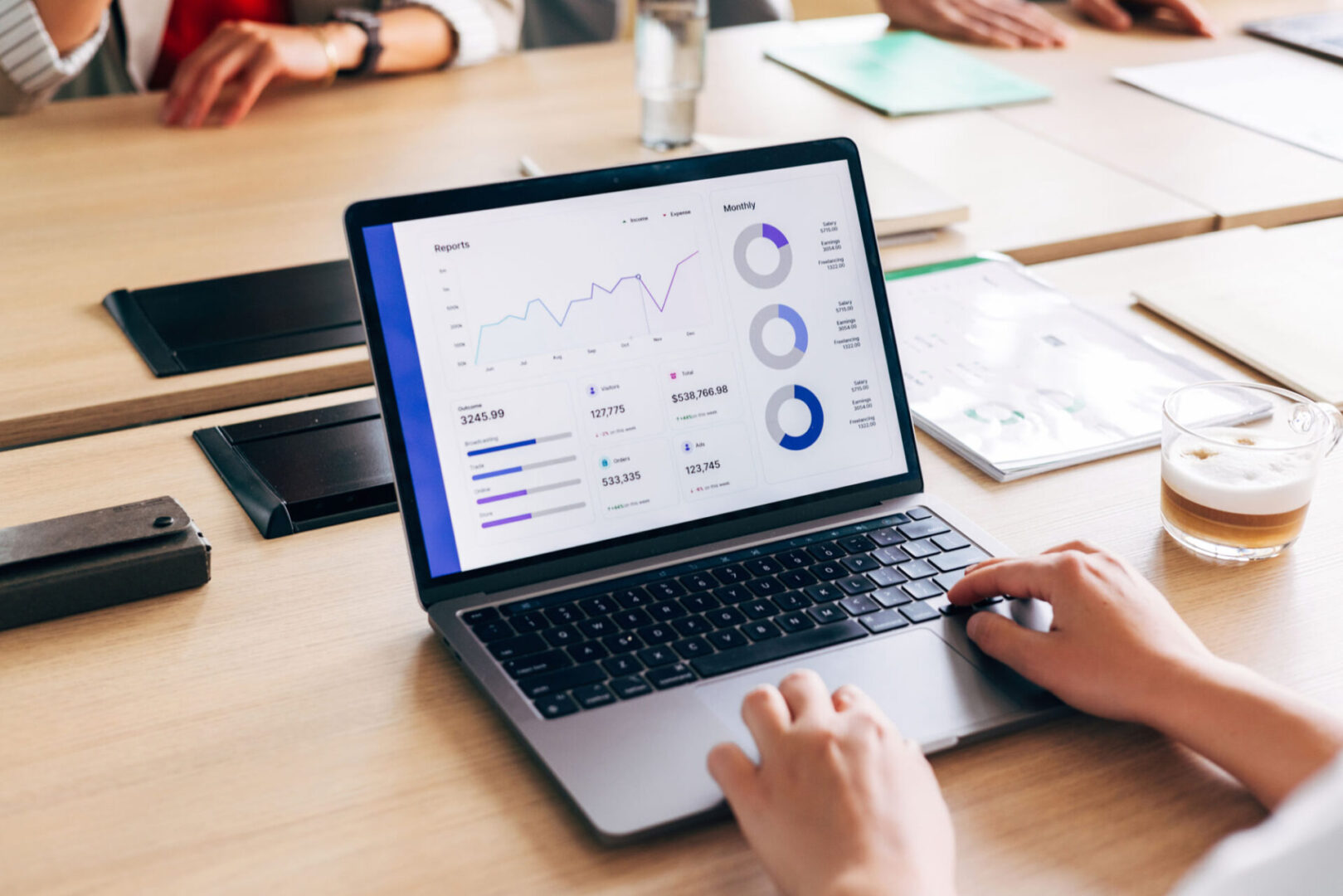 Business meeting with laptop analytics display