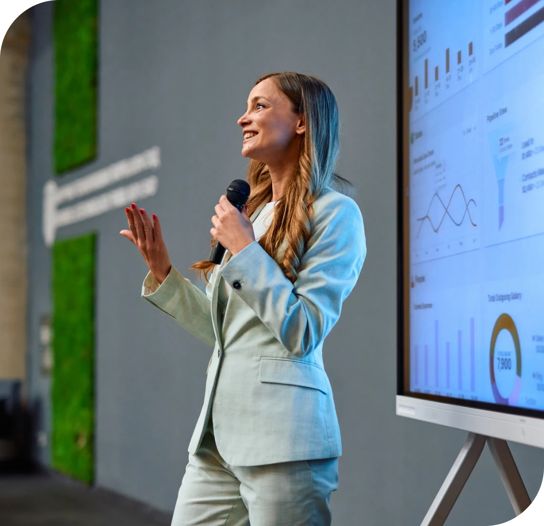 Businesswoman speaking at conference with graphs