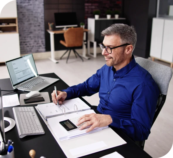 Smiling professional writing notes at desk