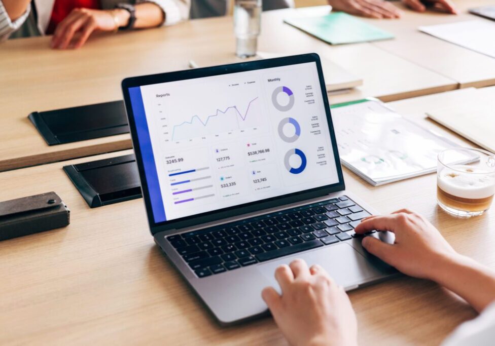 Business meeting with laptop analytics display